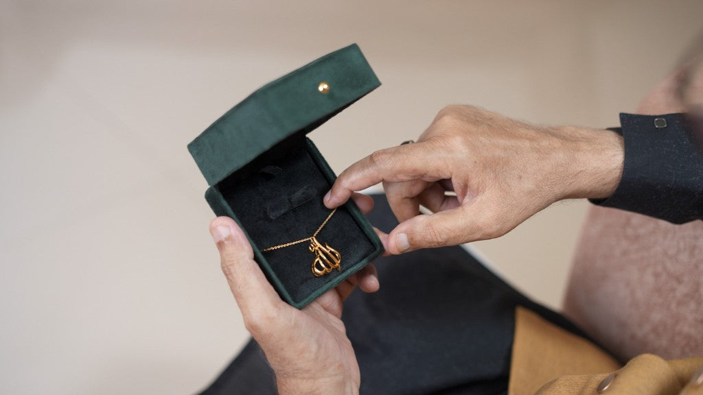 Open jewelry box with Allah calligraphy pendant
